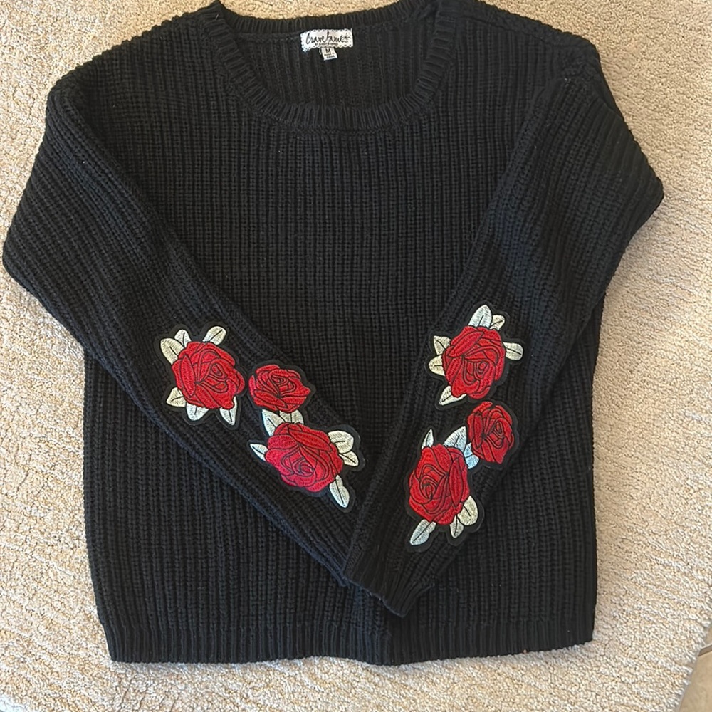 Black sweater with appliquéd roses on sleeves